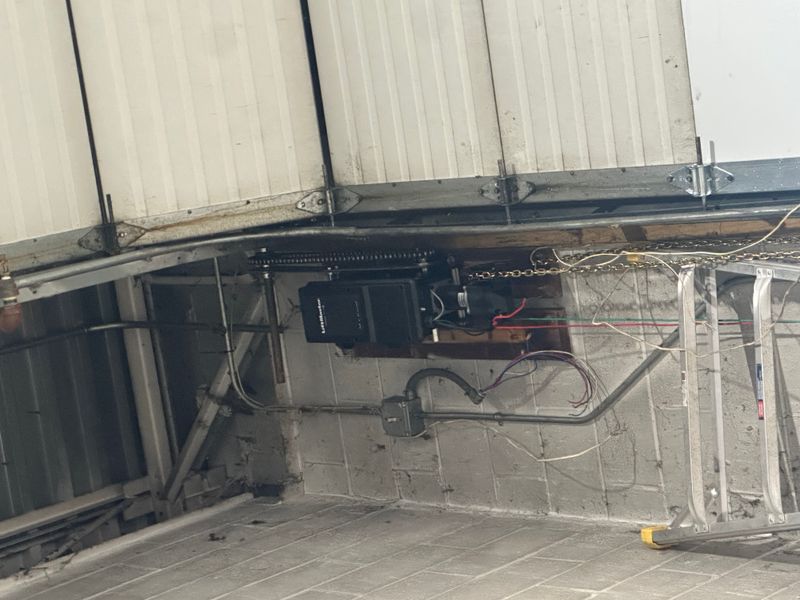 LiftMaster commercial chain drive opener with spring system close-up during service
