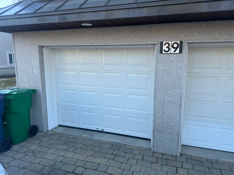 White raised-panel garage door properly aligned after repair